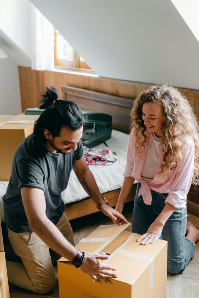 Happy couple unpacking boxes in their new home, creating joyful memories while moving in.